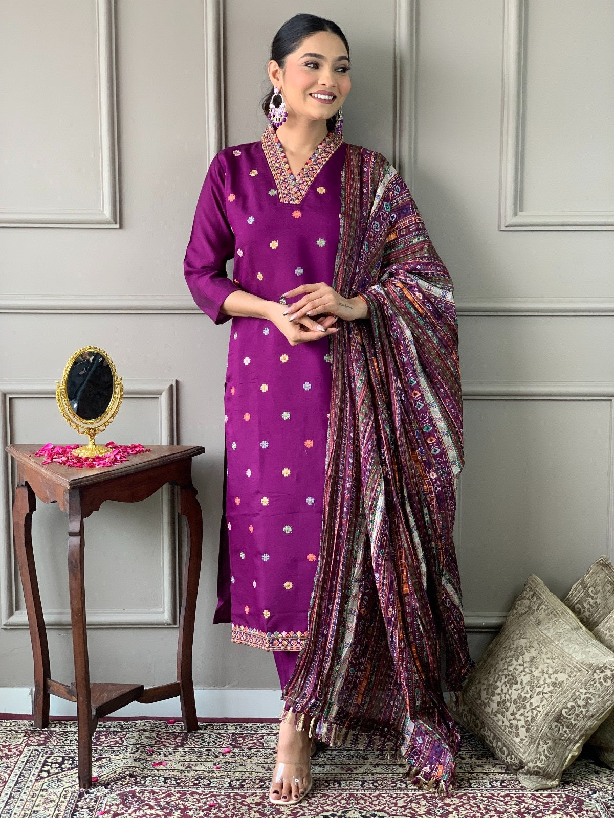 Woman in a purple traditional outfit with a patterned scarf .