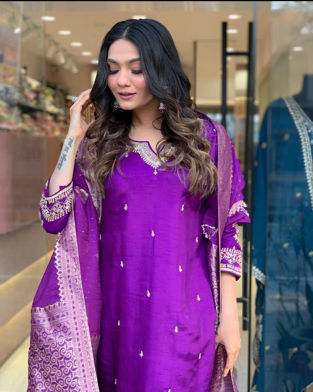Woman in a purple traditional outfit with a matching dupatta.