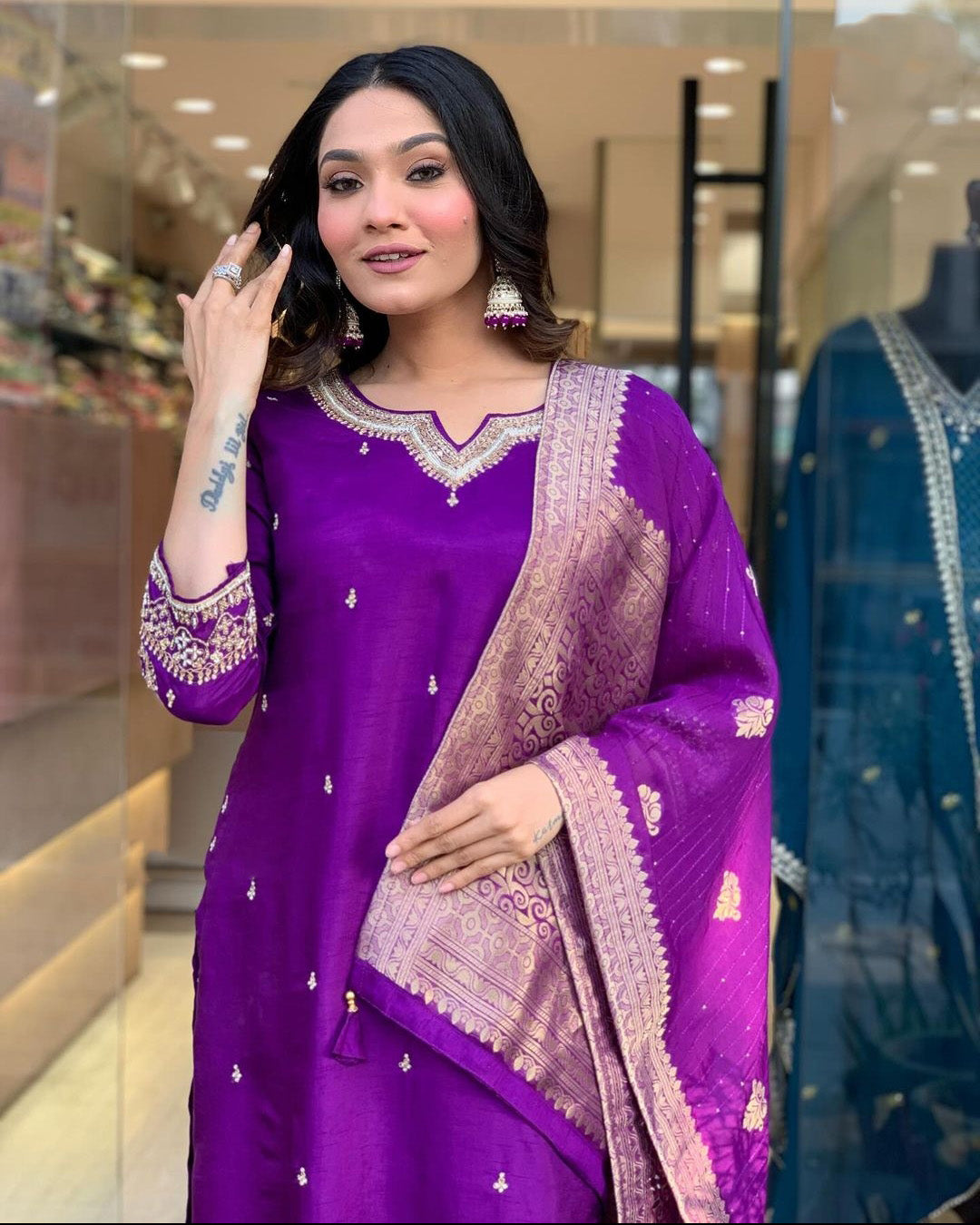 Woman in a purple traditional outfit with a matching dupatta.
