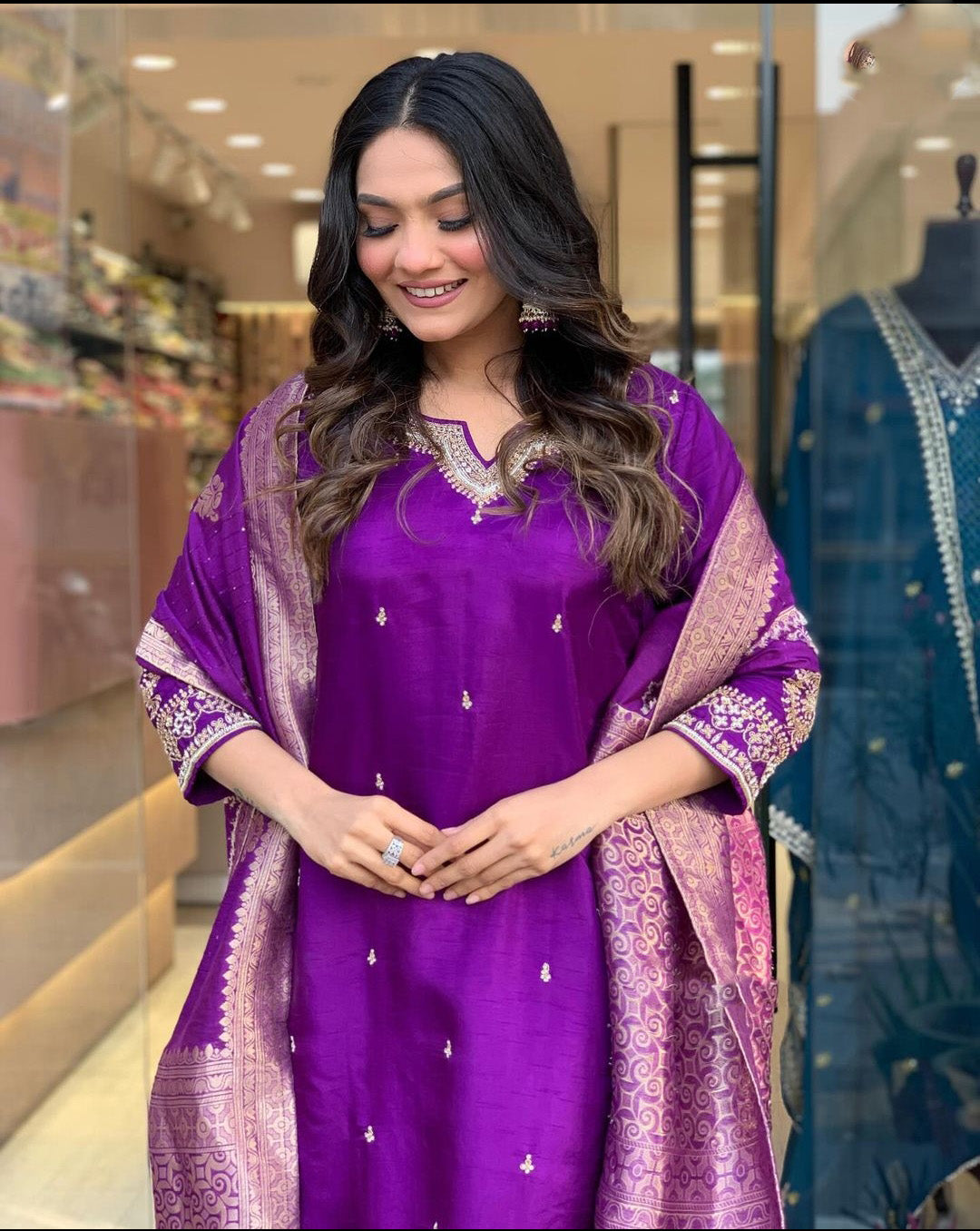 Woman in a purple traditional outfit with a matching dupatta.