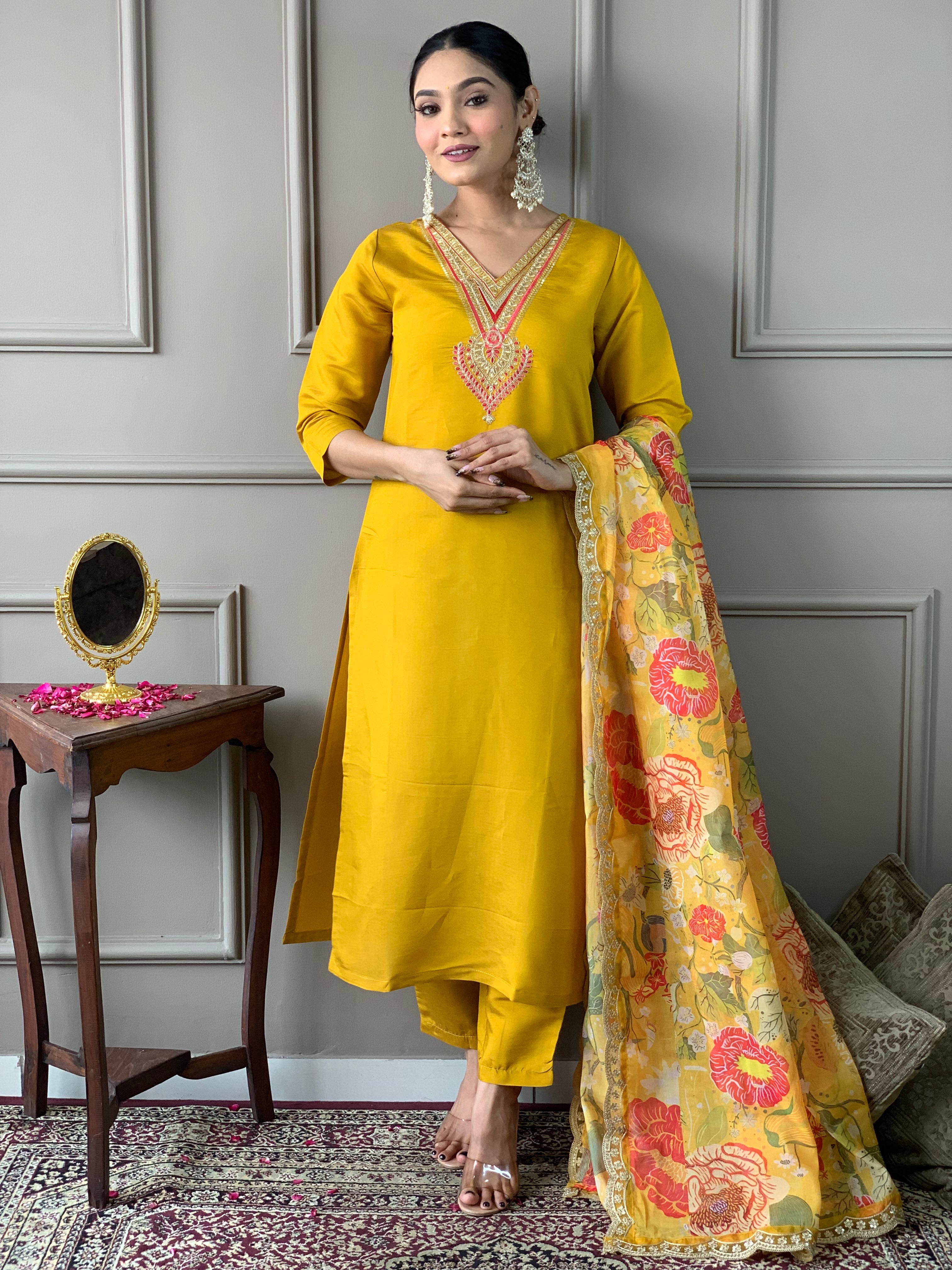 Woman in a yellow traditional outfit with a floral dupatta .