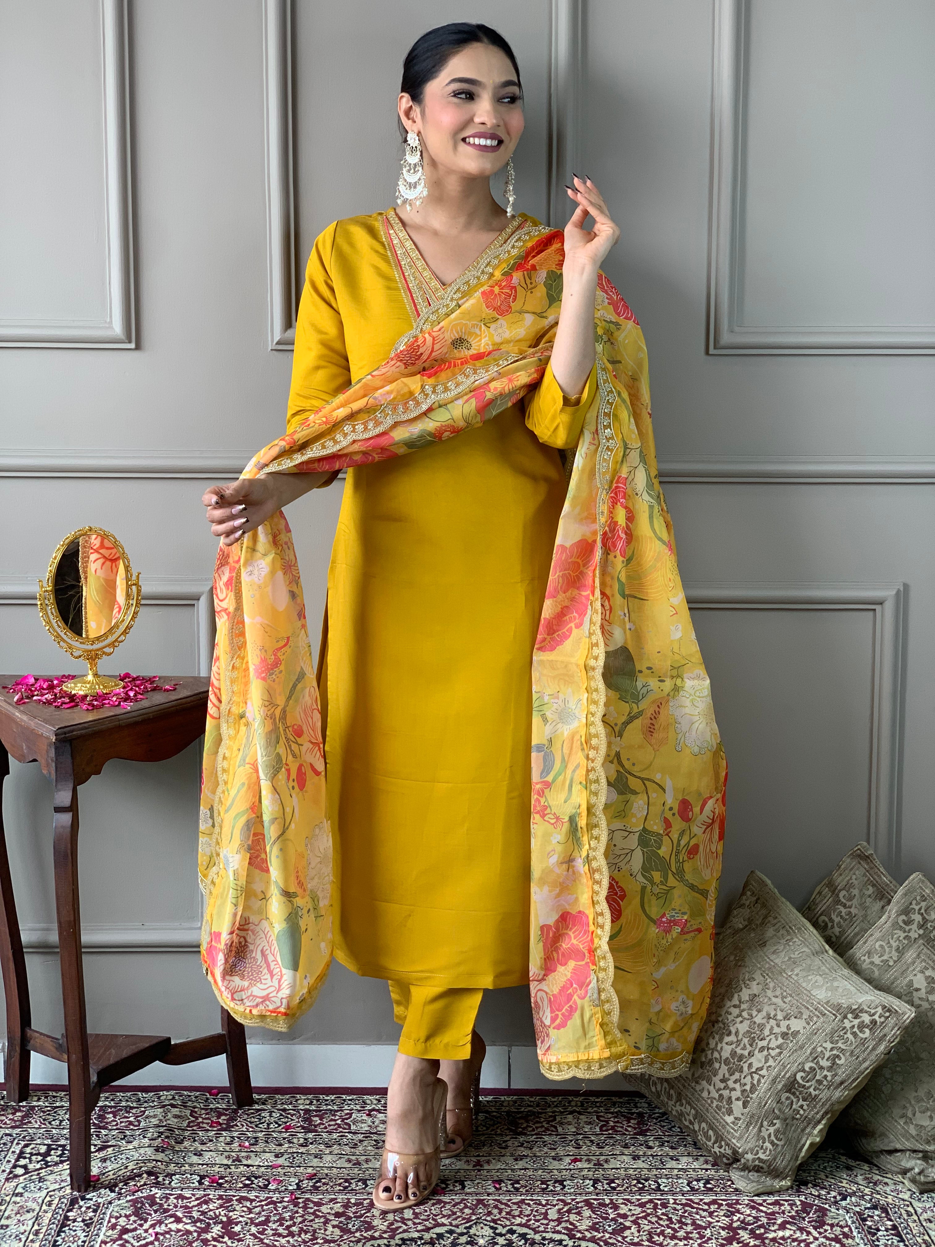 Woman in a yellow traditional outfit with a floral dupatta .