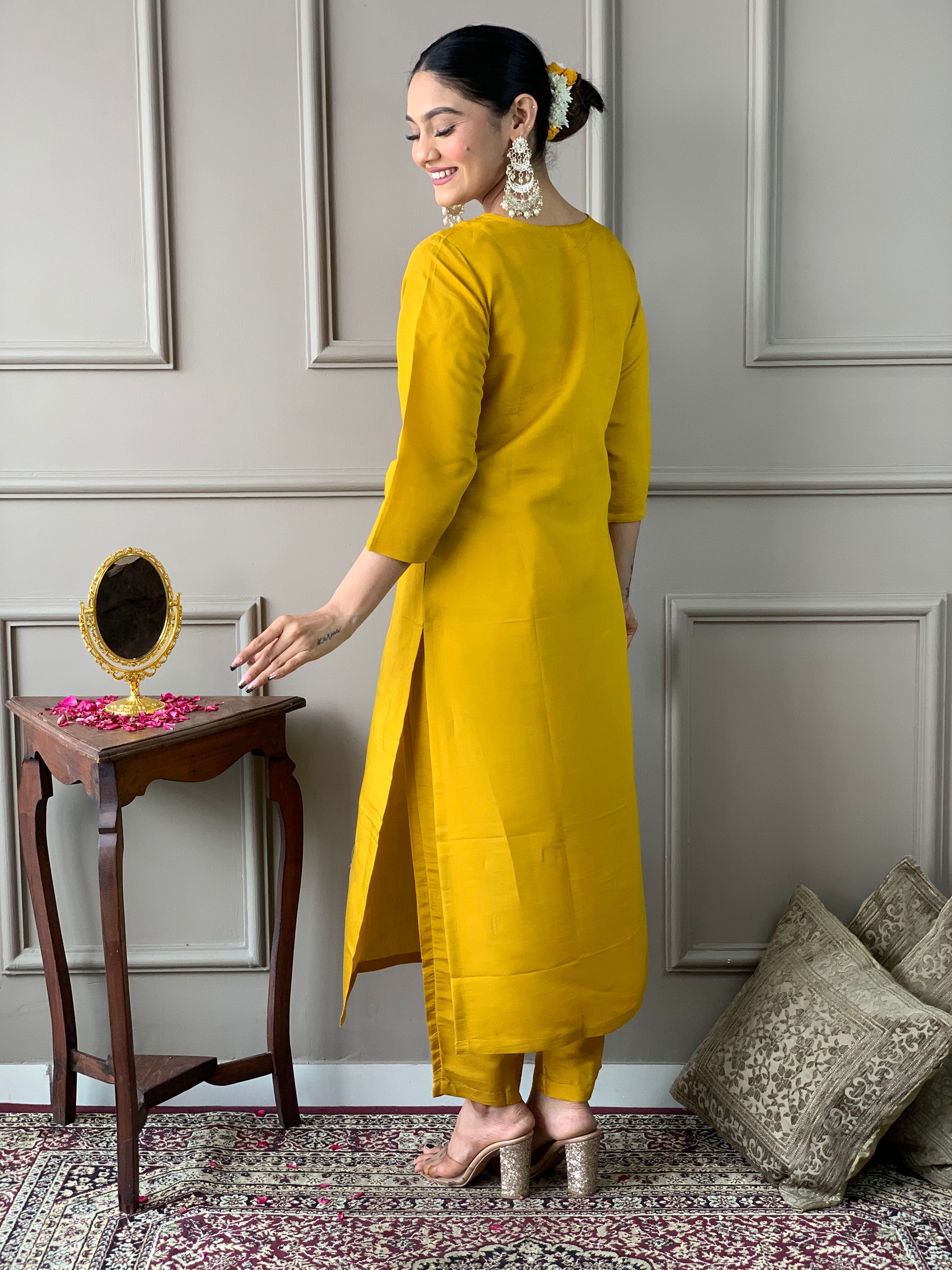 Woman in a yellow traditional outfit with a floral dupatta .