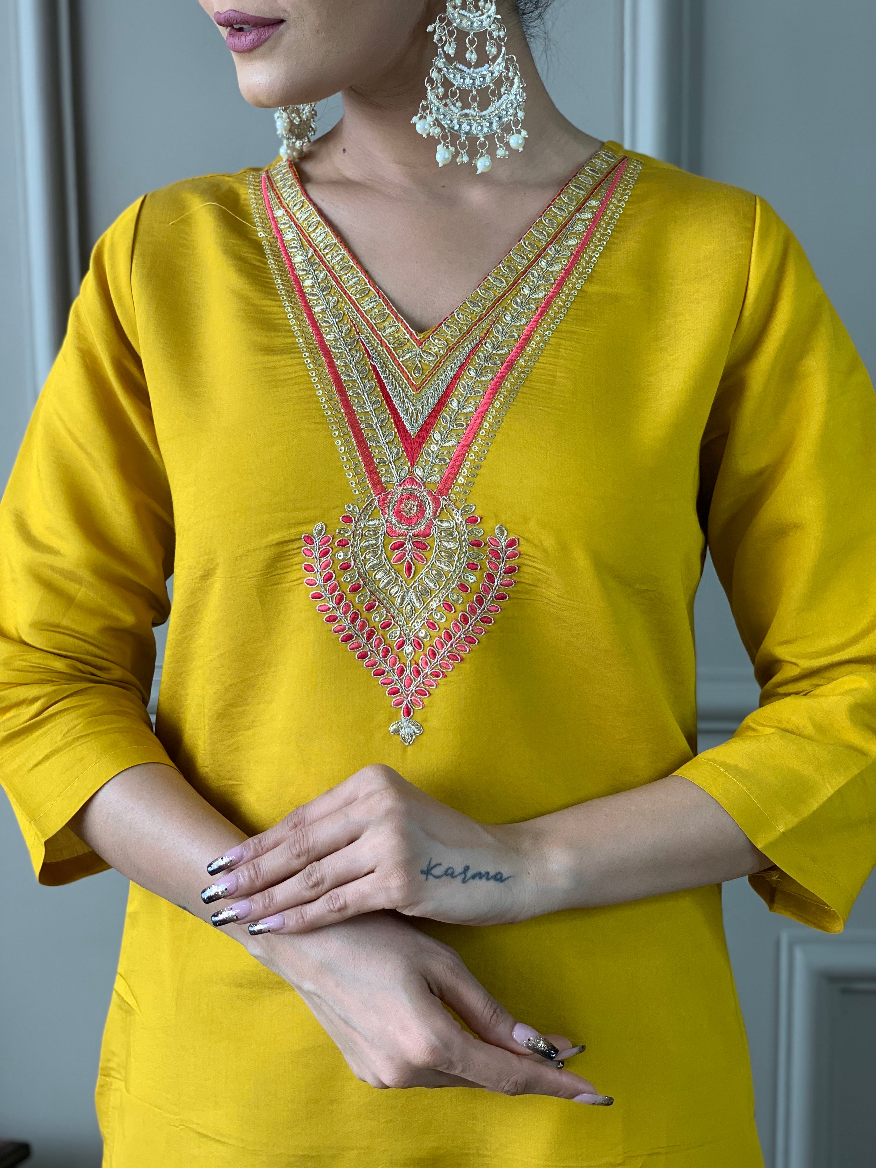 Woman in a yellow traditional outfit with a floral dupatta .