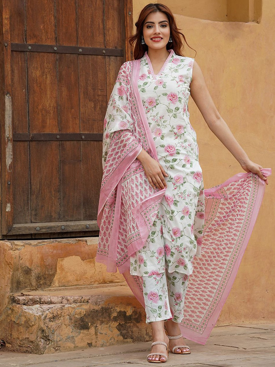 Woman wearing a floral outfit with a dupatta .