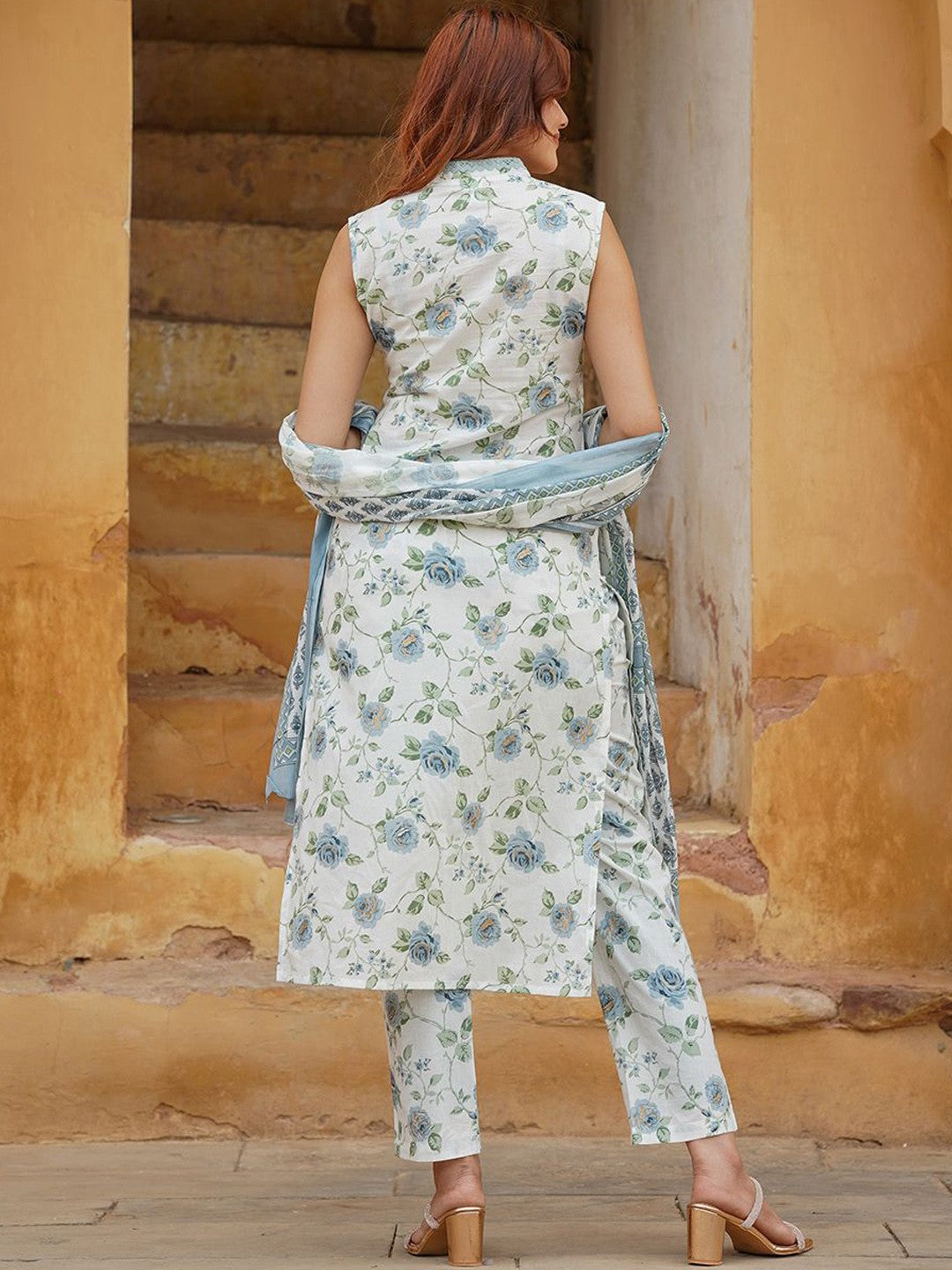 Woman wearing a floral outfit with a dupatta .