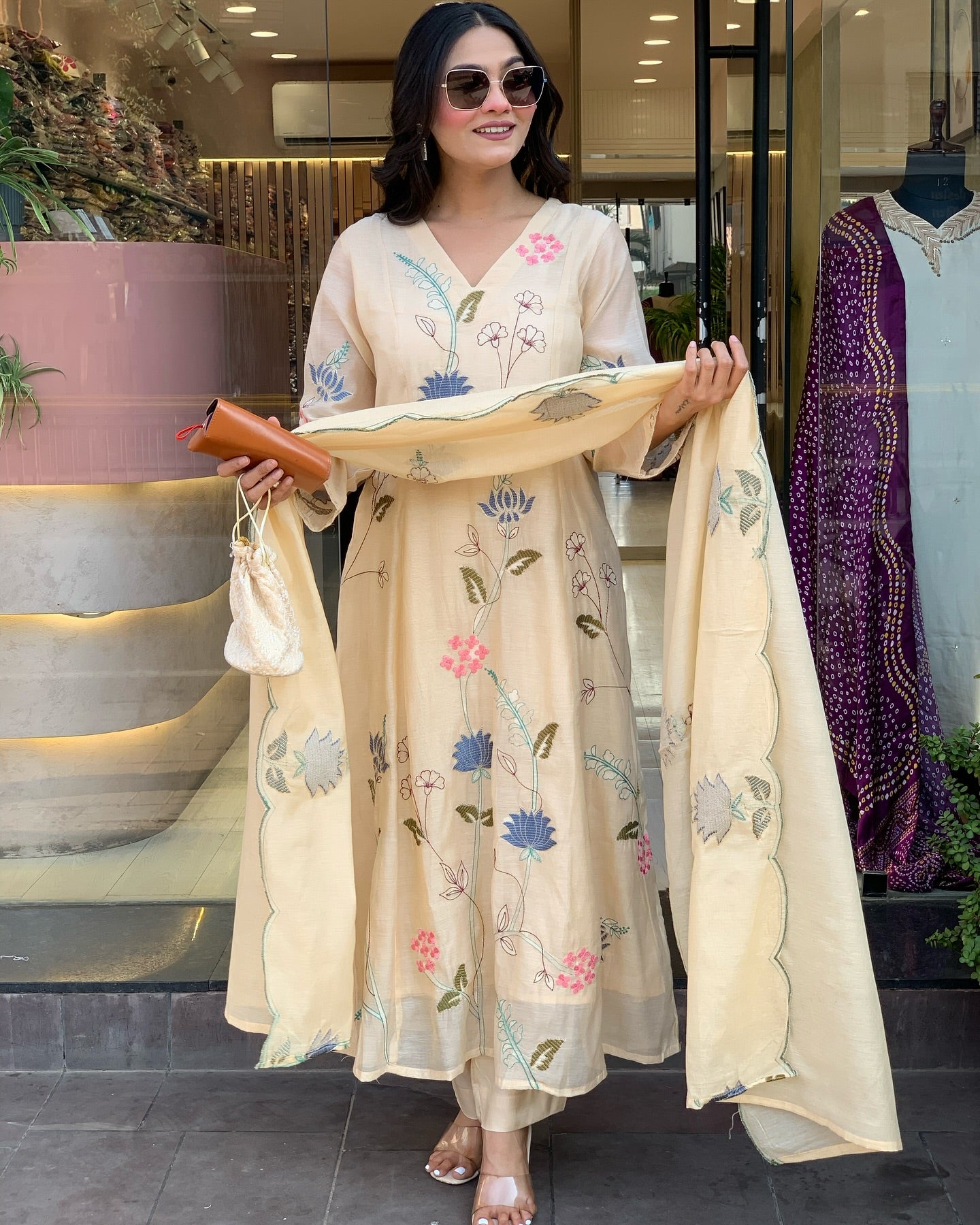 Woman holding a floral embroidered scarf 