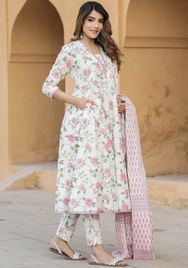 wearing a floral outfit with a pink dupatta