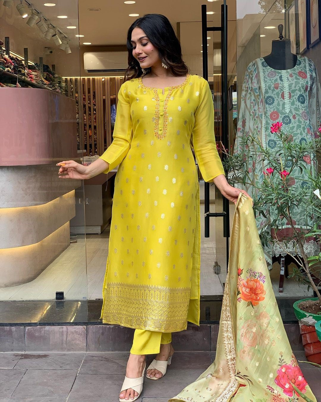 Woman in a yellow traditional outfit with floral dupatta