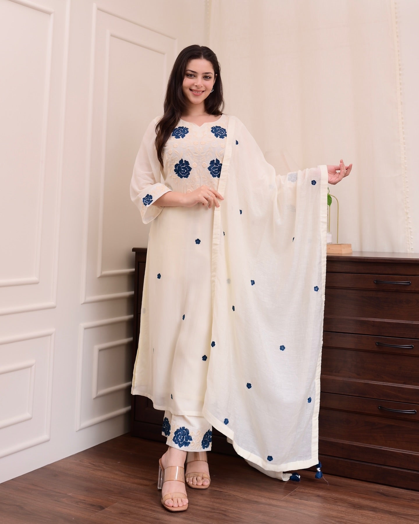 Elegant white outfit adorned with delicate blue floral patterns.