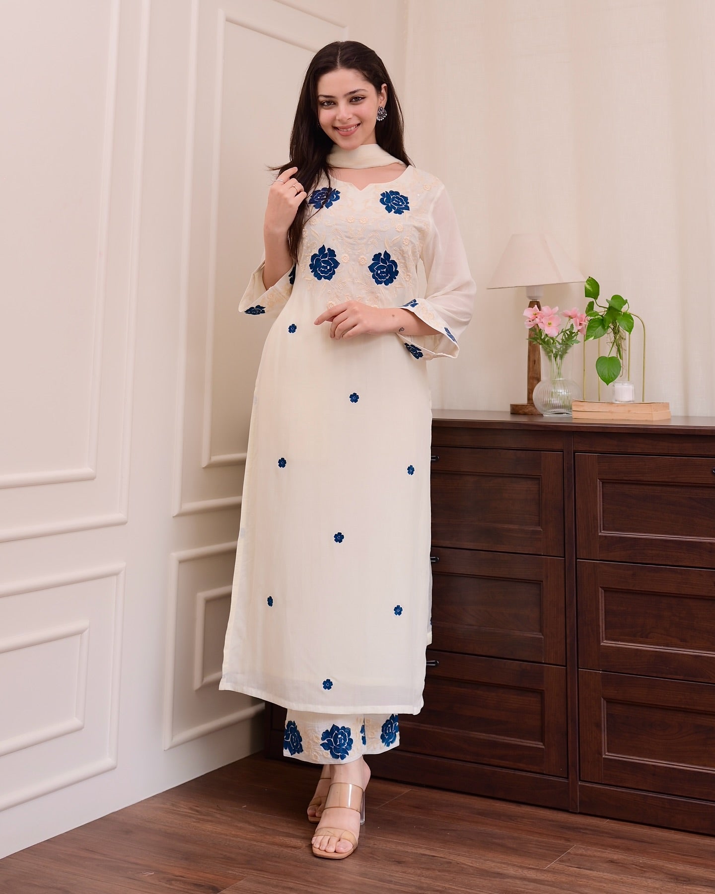 Elegant white outfit adorned with delicate blue floral patterns.