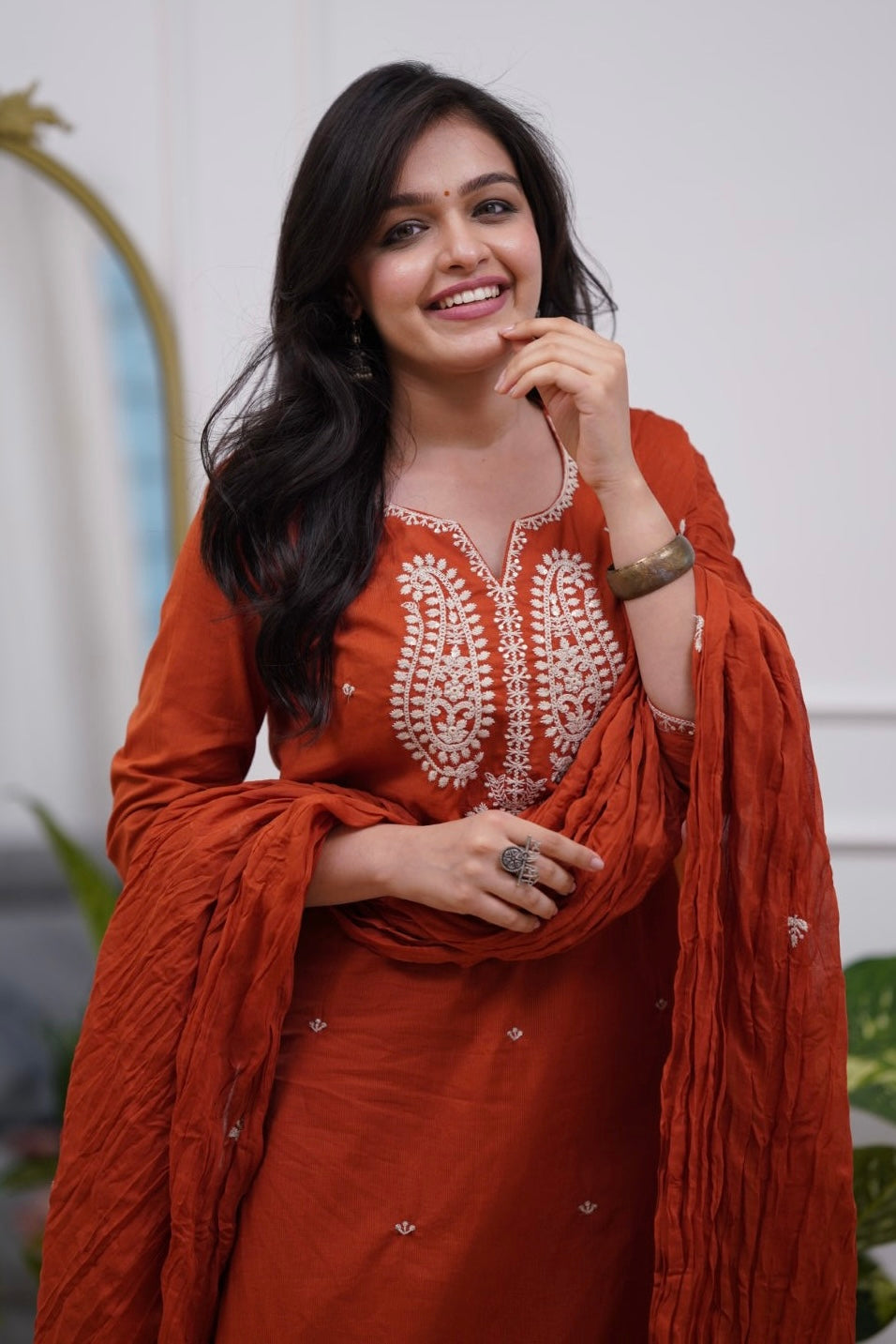 Woman in a rust-colored traditional outfit .