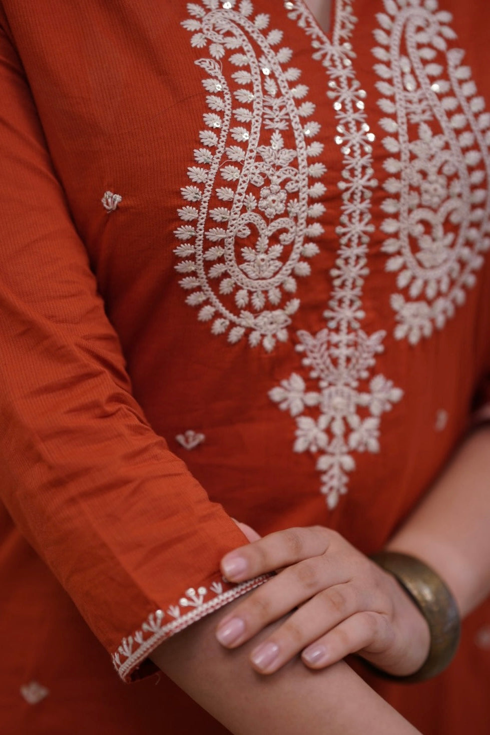 Woman in a rust-colored traditional outfit .