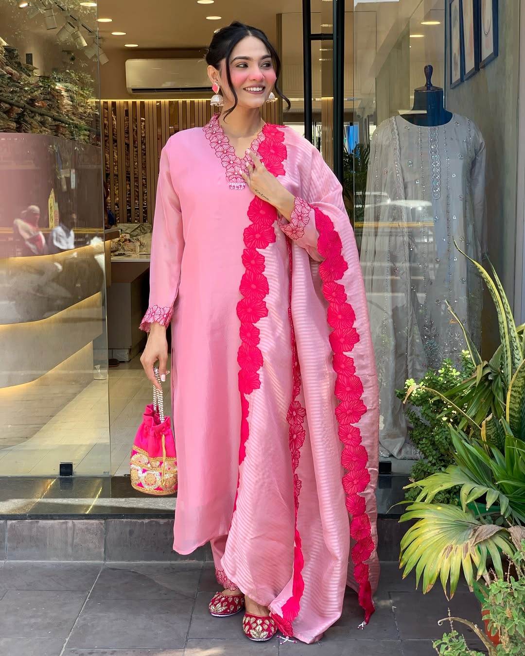 Woman in a pink traditional outfit with red floral patterns 